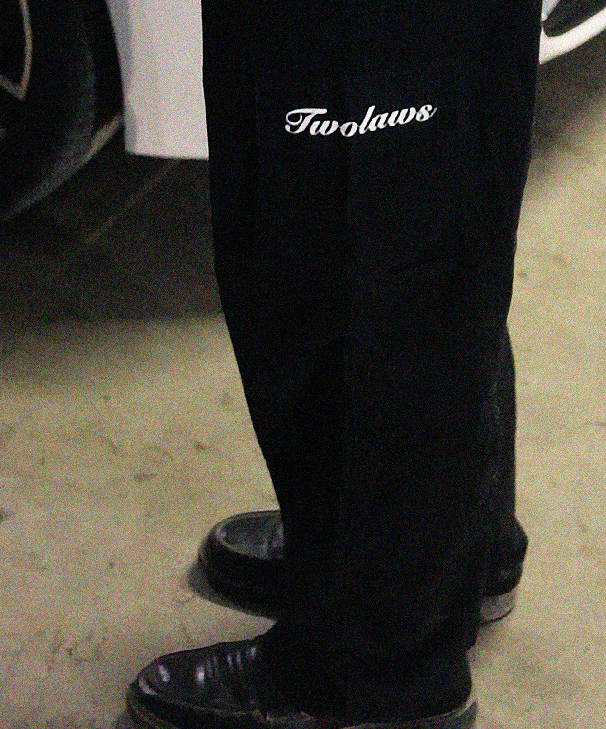 Model wearing TWOLAWS Black Cargo Pants showing utility pockets and tailored fit.