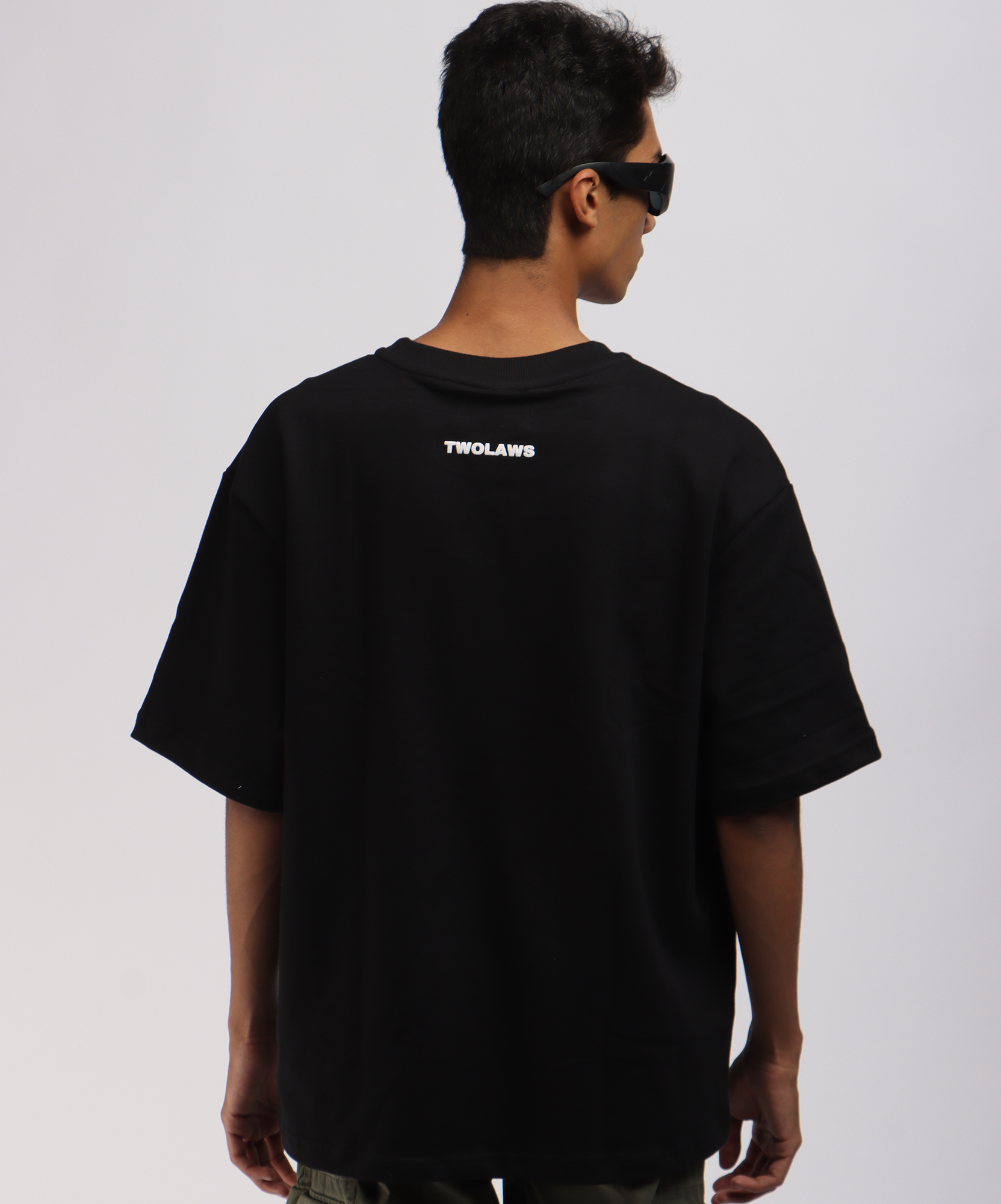 Back view of the model wearing the TWOLAWS Faith & Patience T-shirt Black showing the minimal logo near the neckline.