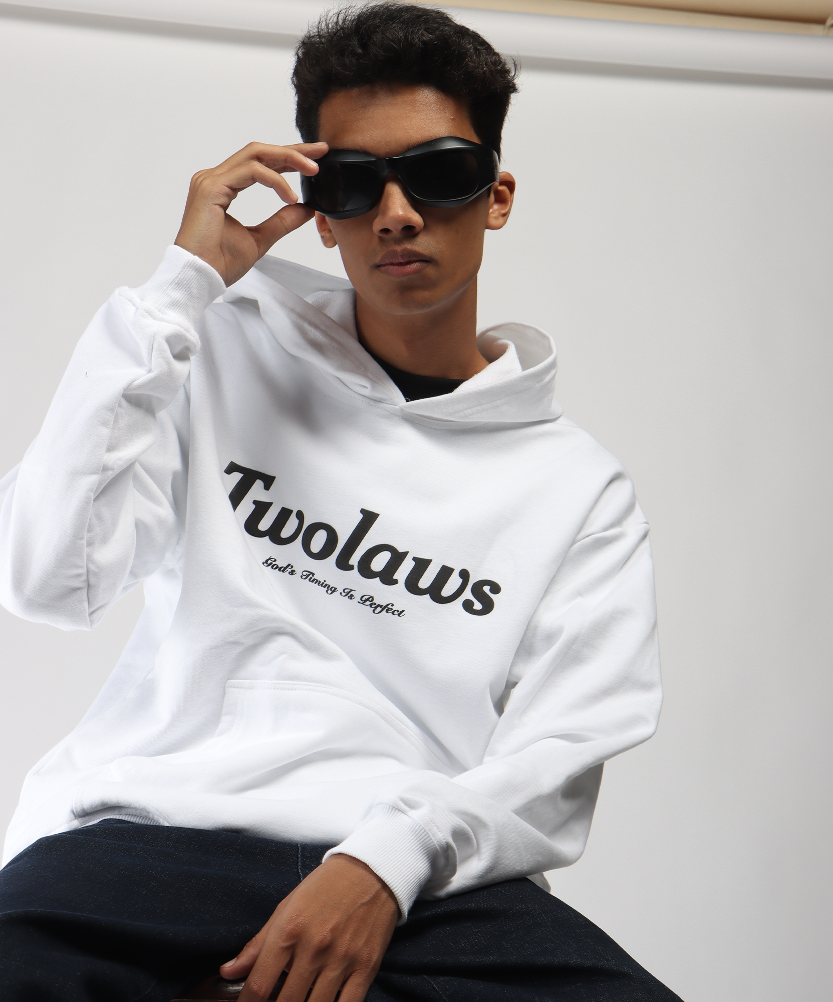 Model wearing TWOLAWS White Faith Hoodie, 'God’s timing is perfect' quote on front with relaxed oversized fit.