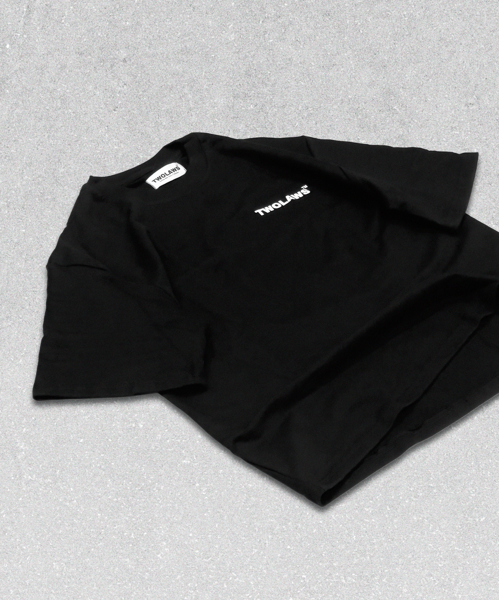 TWOLAWS Logo T-Shirt in black with bold front branding and oversized fit, laid flat on the floor.