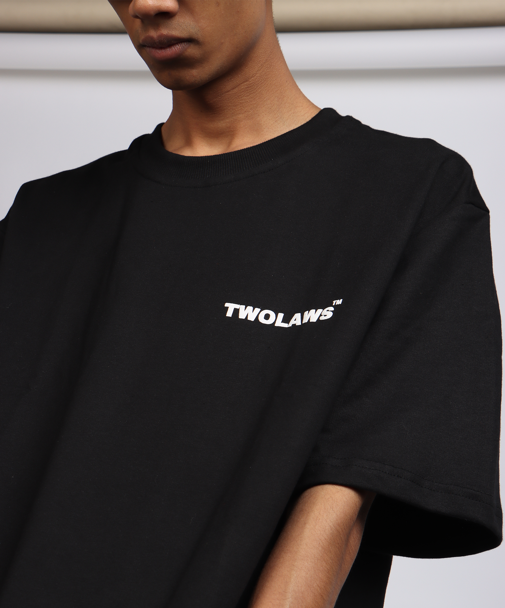 Close-up of TWOLAWS Logo T-Shirt in black with bold front branding and oversized fit.